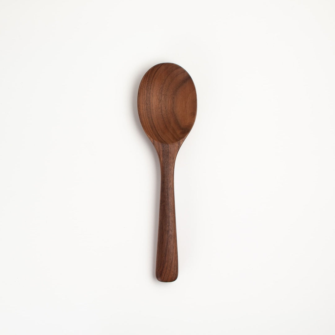 A single wooden spoon with a dark brown finish and visible wood grain, photographed vertically against a clean white background.
