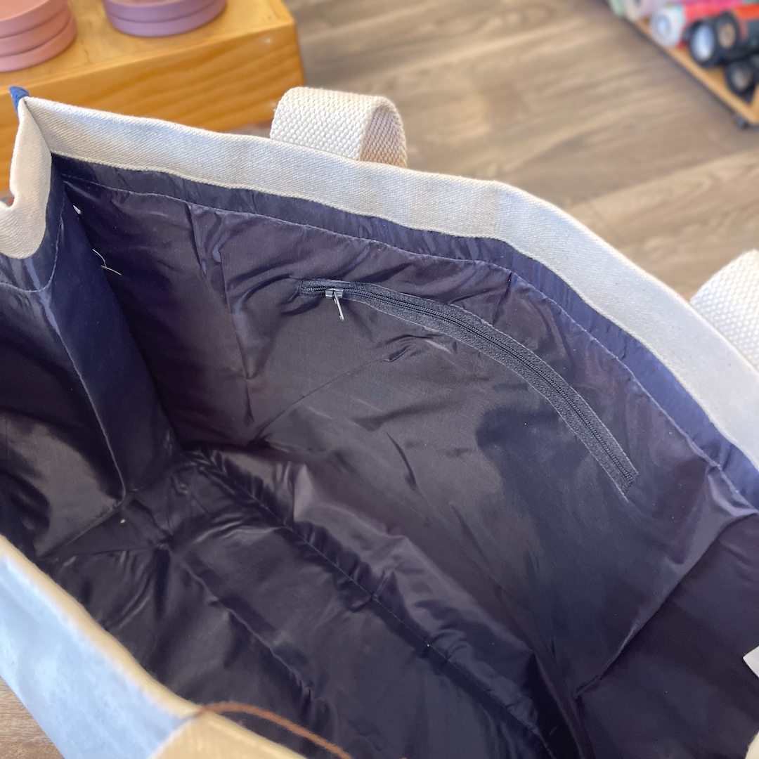 Blue interior of tote bag with zipper side pocket.