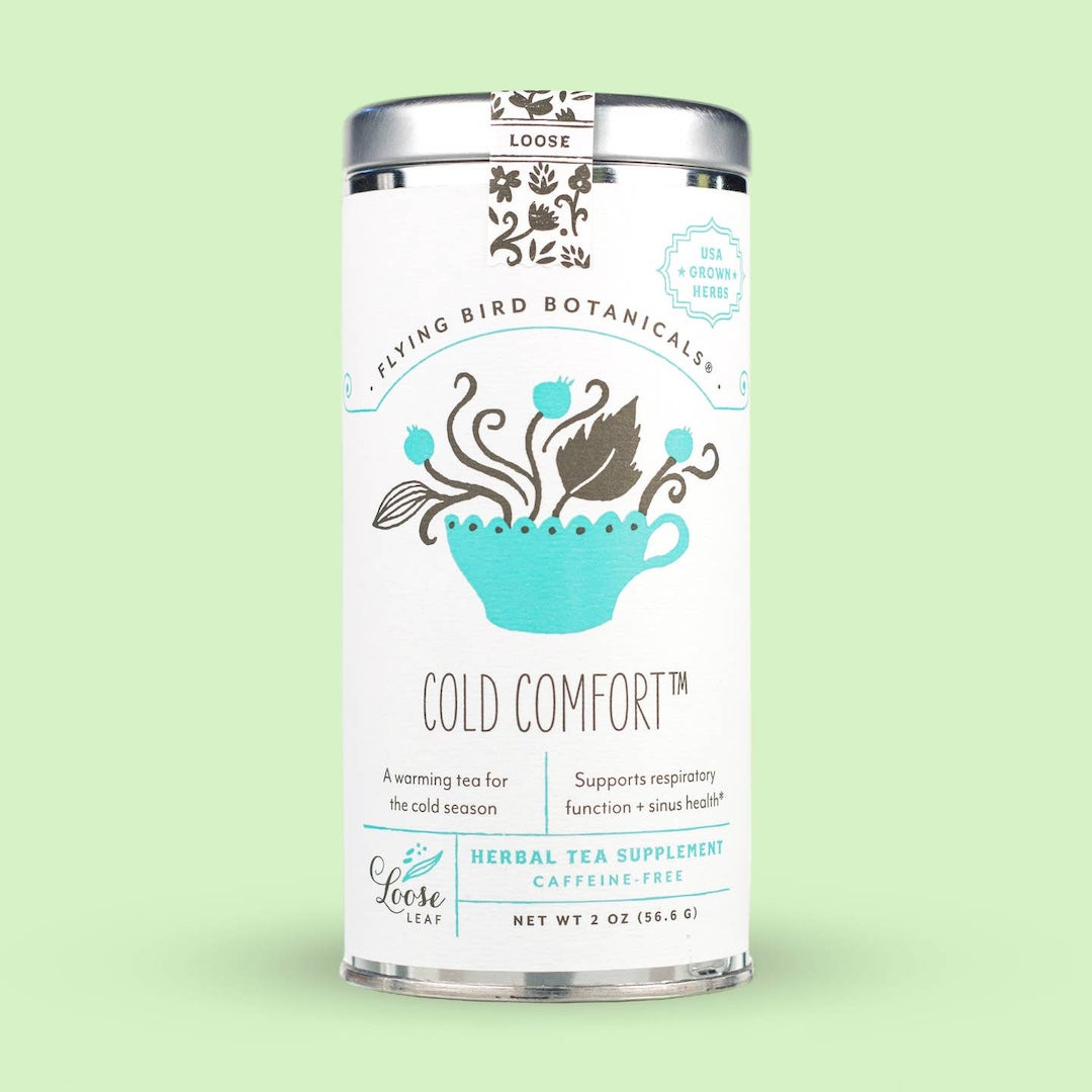 Tea canister labeled 'Cold Comfort' by Flying Bird Botanicals on a light green background