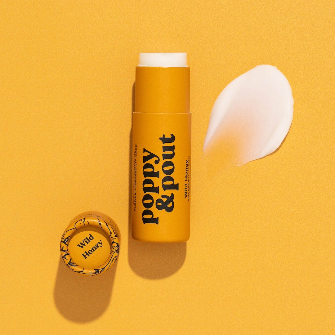 Tube of Lip Balm from Poppy & Pout in the scent Wild Honey on a yellow background