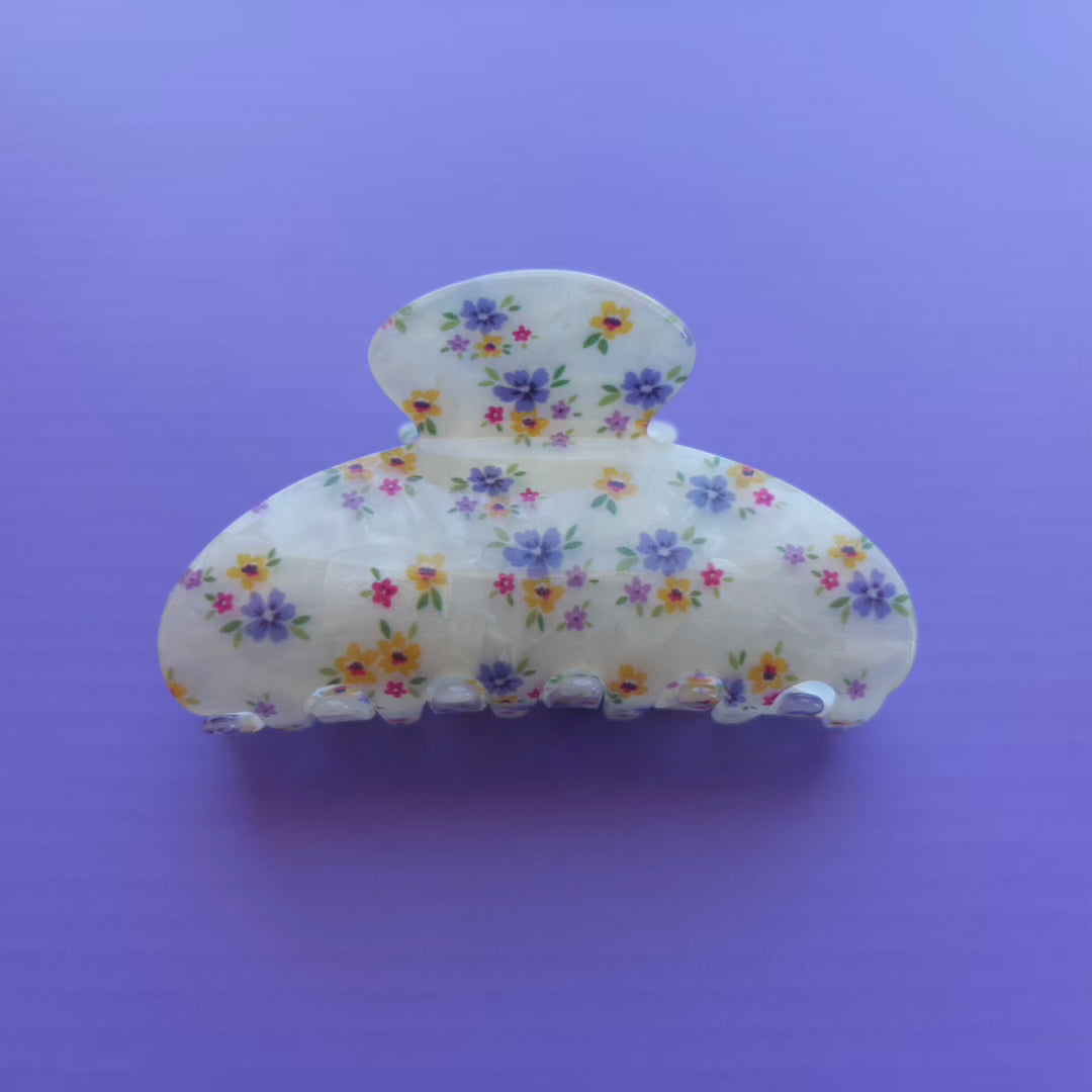 Floral-patterned hair clip on a purple background
