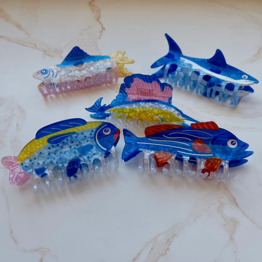 Set of fish-shaped hair clips on a marble surface