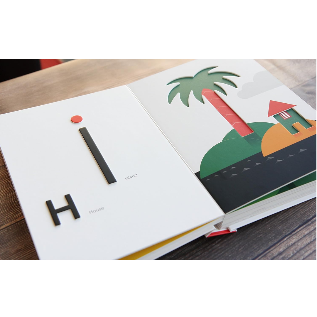 Open book with colorful illustrations of a palm tree and hut on a wooden surface