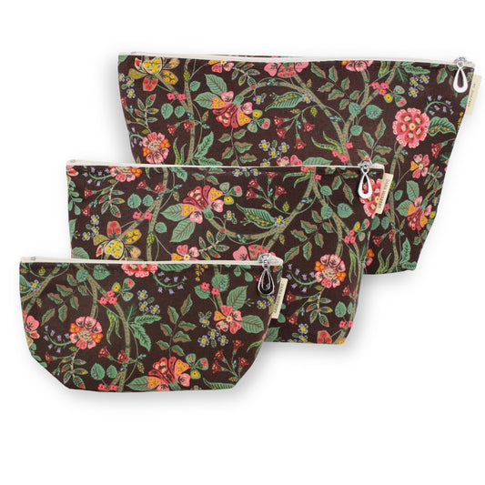 Three floral zippered pouches in different sizes, arranged diagonally on a white background. The pouches feature a dark brown base with a vibrant multicolor botanical pattern of pink flowers, green leaves, and yellow accents.