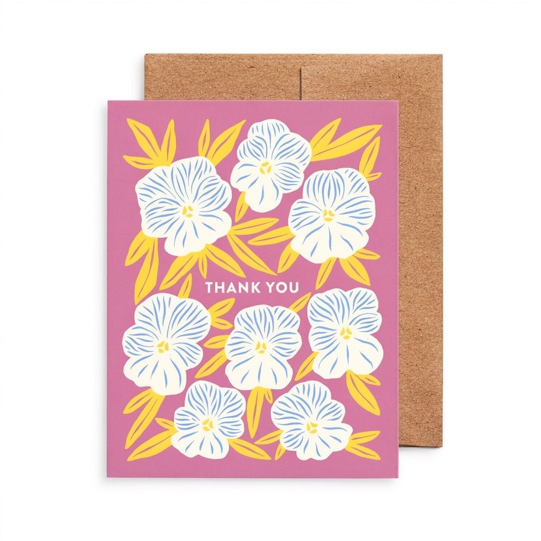 Greeting card with floral design and 'Thank You' text on a pink background, accompanied by a brown envelope.