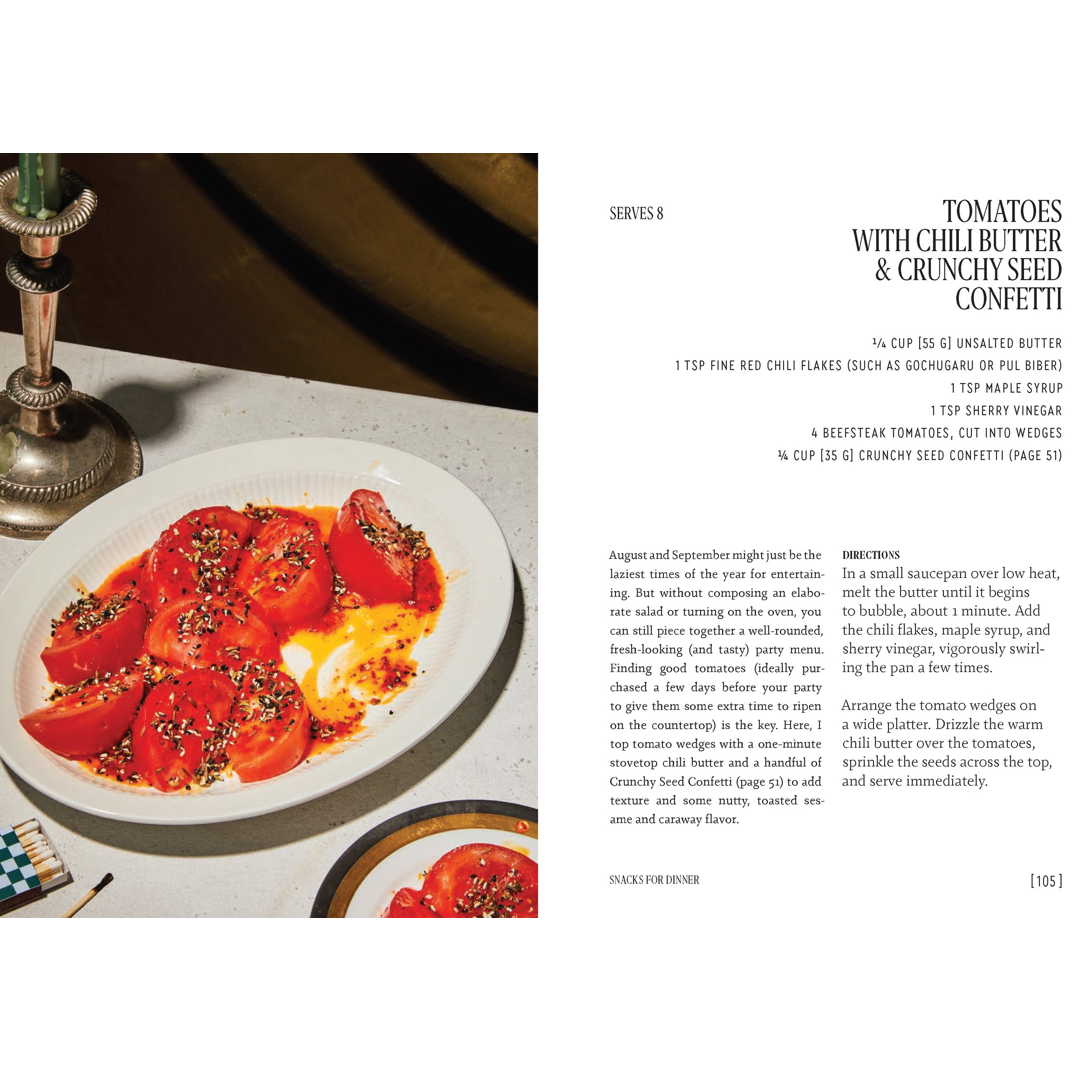 A cookbook page showing the text 'TOMATOES WITH CHILI BUTTER & CRUNCHY SEED CONFETTI' with ingredients, directions, and photos of prepared tomato dishes on a tabletop.