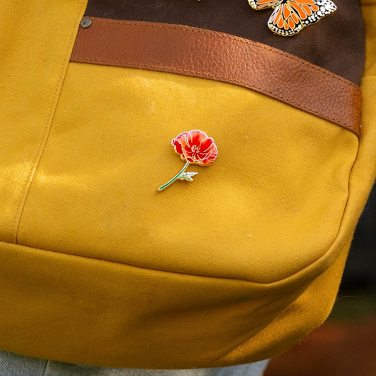 Poppy pin on a yellow bag