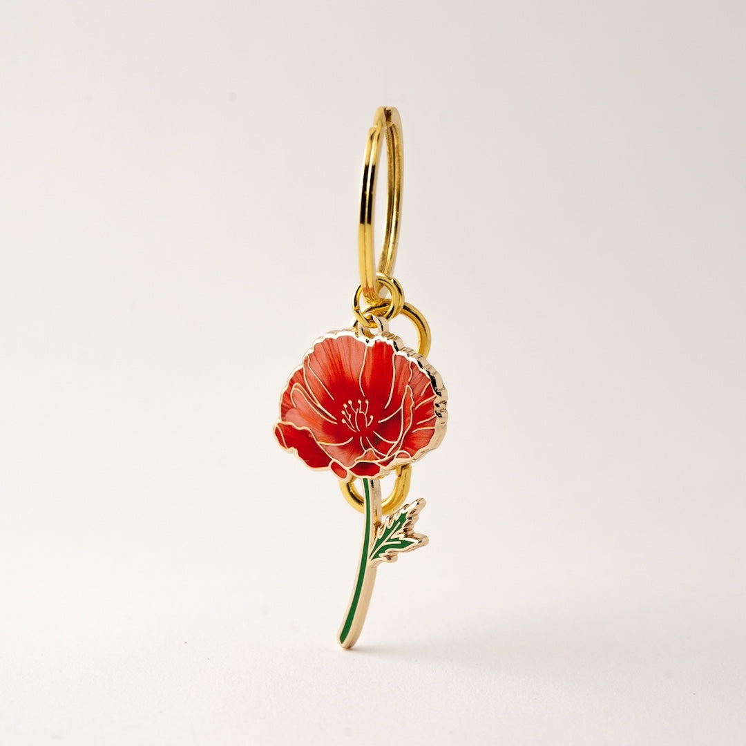 red poppy keychain/bag charm on a white background