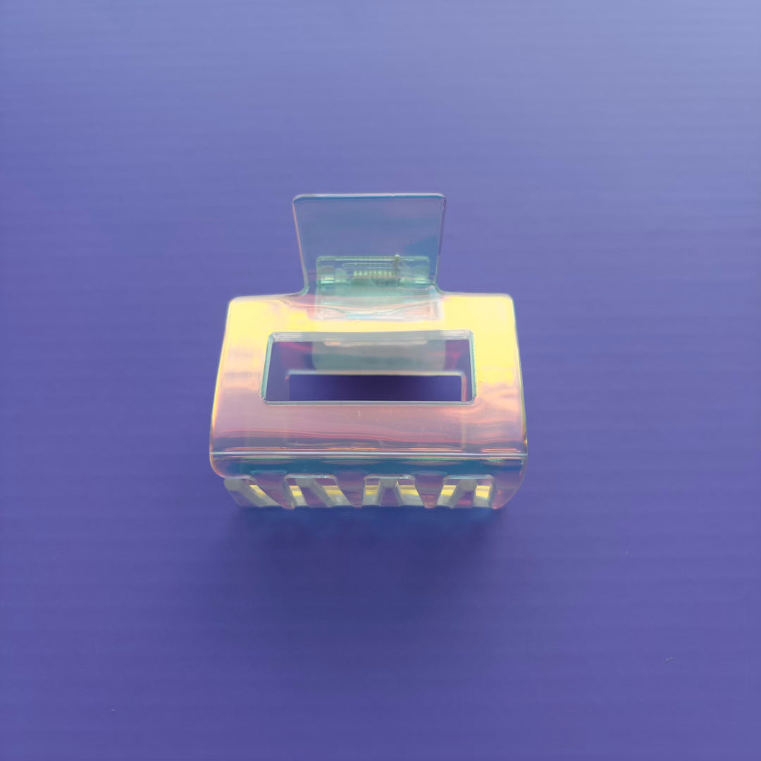 square iridescent claw clip on a purple background
