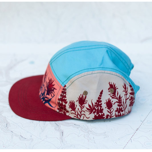 Color-blocked cap with floral pattern on a textured white background