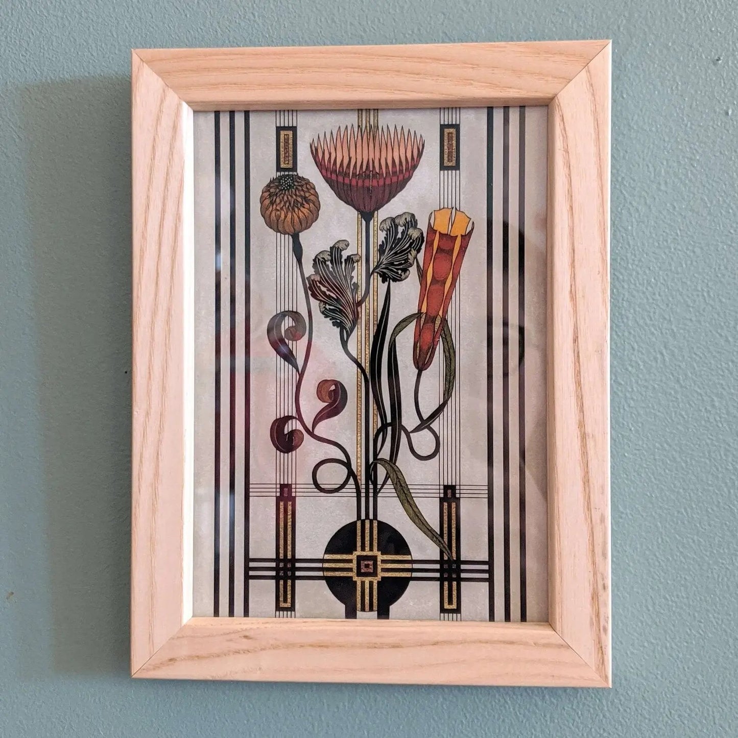 Framed artwork with stylized floral design on a wall