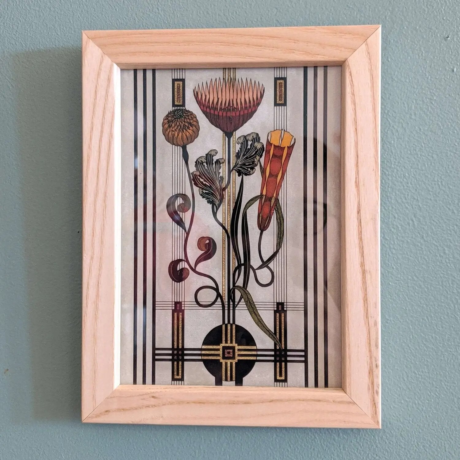 Framed artwork with stylized floral design on a wall