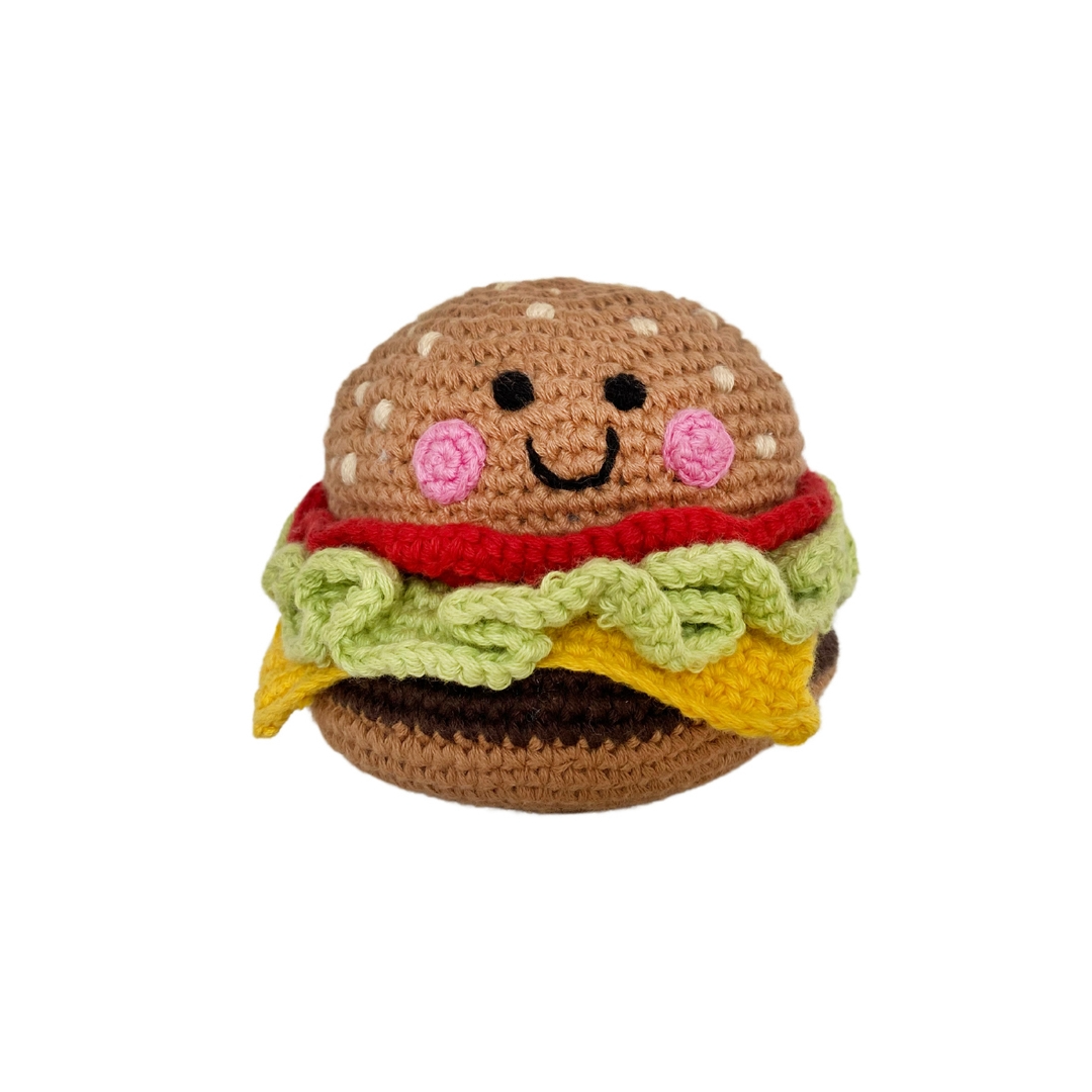 Crocheted toy resembling a hamburger with a smiling face on a white background