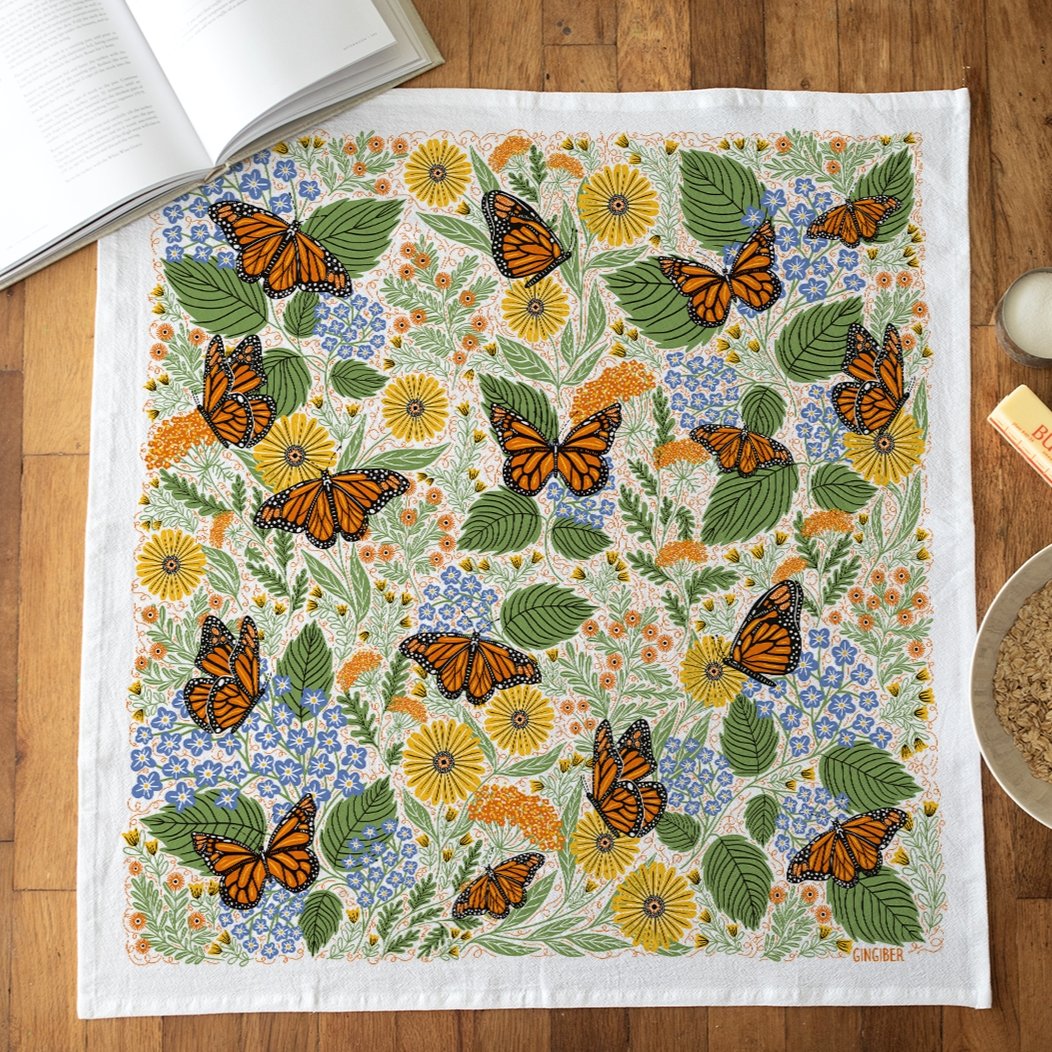 Butterfly and floral patterned towel on a wooden surface