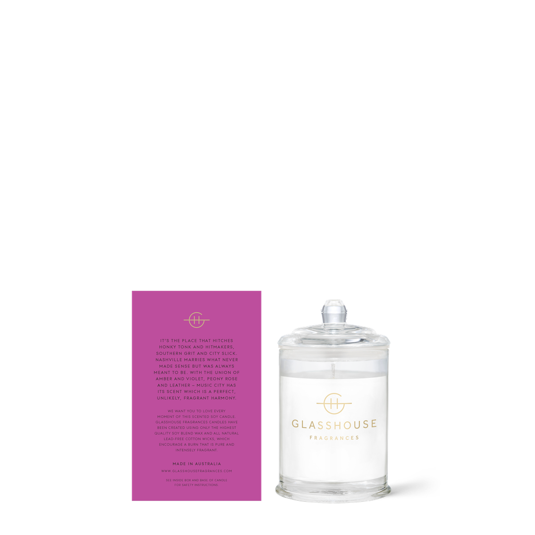 Glasshouse candle with its purple box on a white background