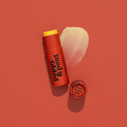 Tube of Lip Balm from Poppy & Pout in the scent blood orange mint on an orange background