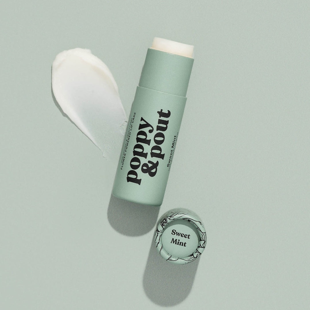 Tube of Lip Balm from Poppy & Pout in the scent Sweet Mint on a blue background