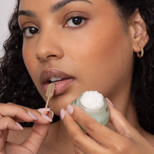 Woman applying a lip scrub with a small spatula