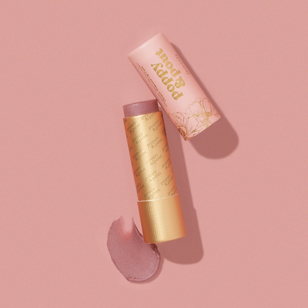 Beverly Lip Tint from Poppy & Pout in a gold tube on a pink background