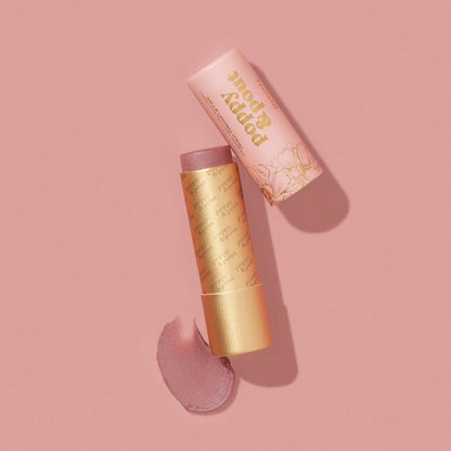 Beverly Lip Tint from Poppy & Pout in a gold tube on a pink background