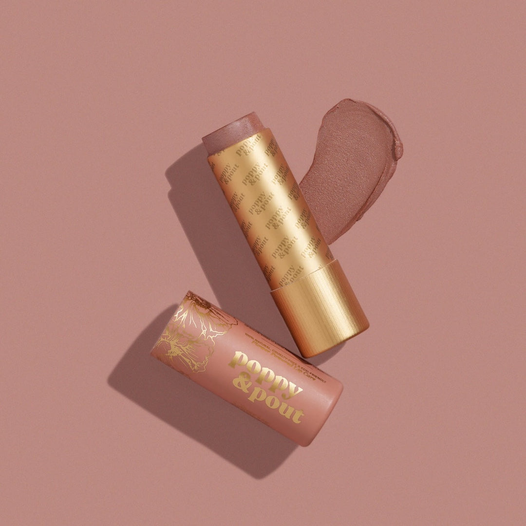 Poppy & Pout Charlie lip tint in a gold tube on a mauve background