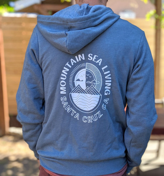 Blue hoodie with 'Mountain Sea Living Santa Cruz CA' logo on the back, worn by a person.