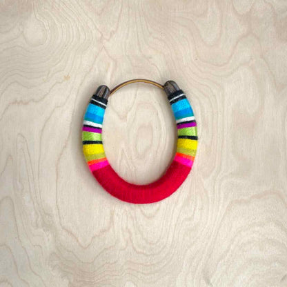 Colorful yarn wrapped horseshoe with blue top and red bottom.