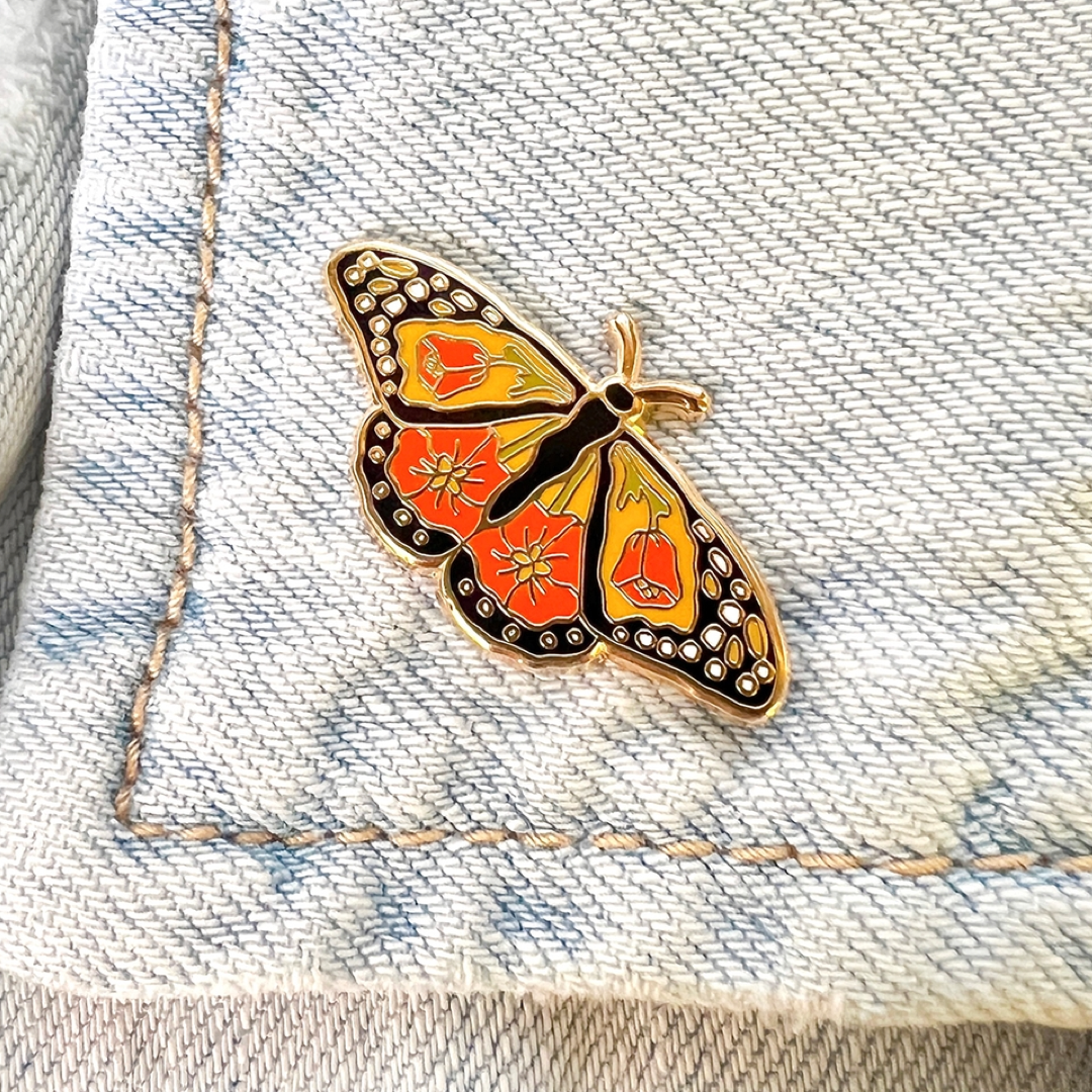Butterfly-shaped pin on a denim background