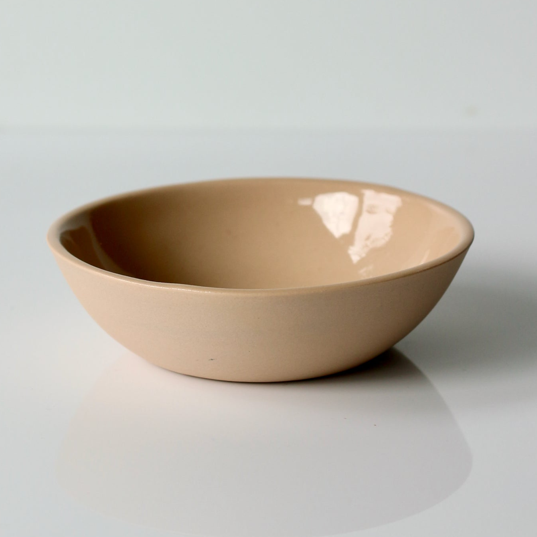 Peach ceramic bowl on a light gray background