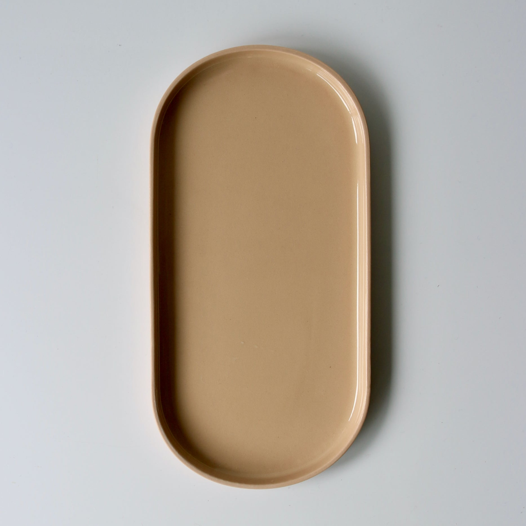 Peach oval ceramic tray on a light gray background