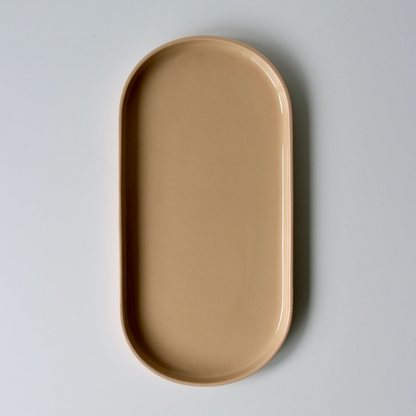 Peach oval ceramic tray on a light gray background