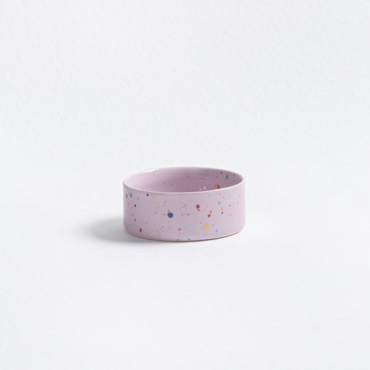 Pink ceramic bowl with multicolored speckles on a light gray background