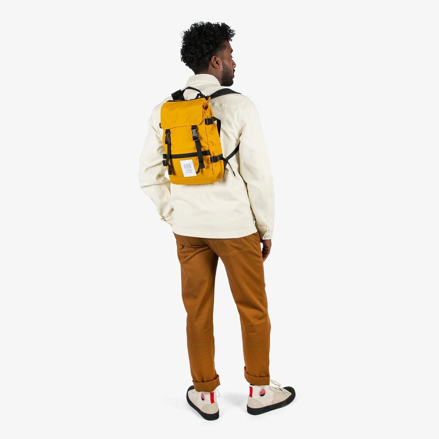 Person wearing a yellow backpack on a white background