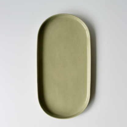 Sage green oval ceramic tray on a white background