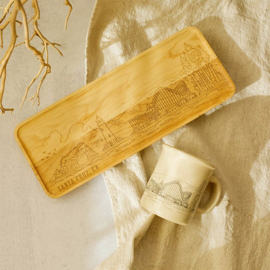 Wooden tray and mug with engraved designs on a textured beige surface