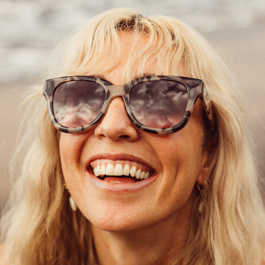 Woman wearing sunglasses with a blurred natural background