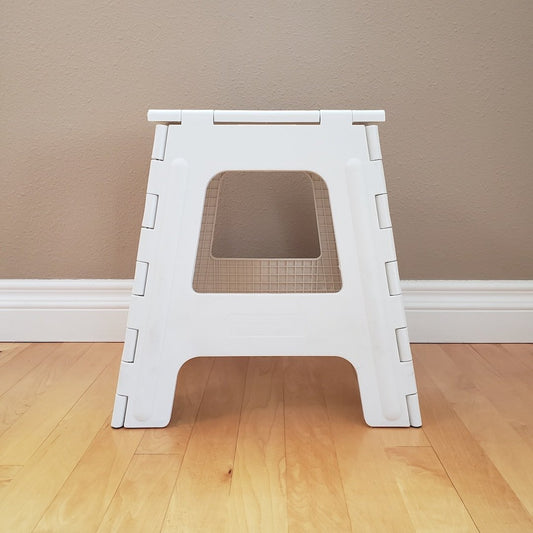 White step stool on a wooden floor.