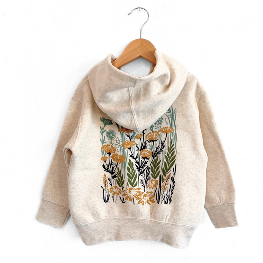 Beige hoodie with floral design on a wooden hanger against a white background
