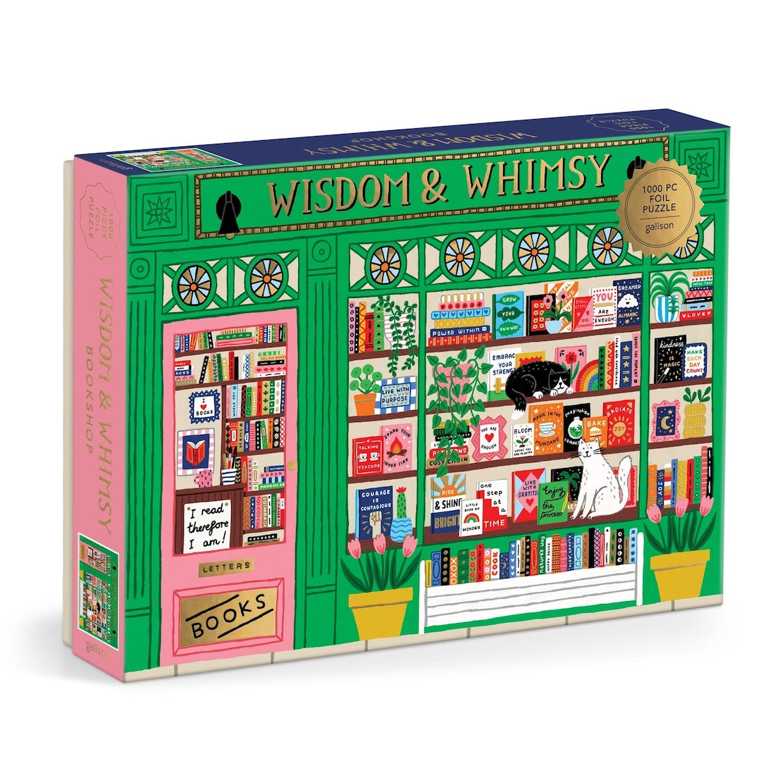 A 1000-piece jigsaw puzzle box titled 'WISDOM & WHISMSY' featuring a colorful illustration of a bookshop facade with shelves, books, potted plants, and cats. The box is shown at a three-quarter angle on a plain white background.