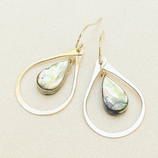 Teardrop-shaped earrings with abalone on a beige background
