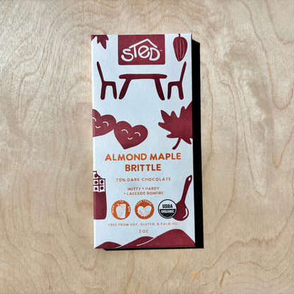Almond Maple Brittle chocolate bar in packaging on a wooden surface