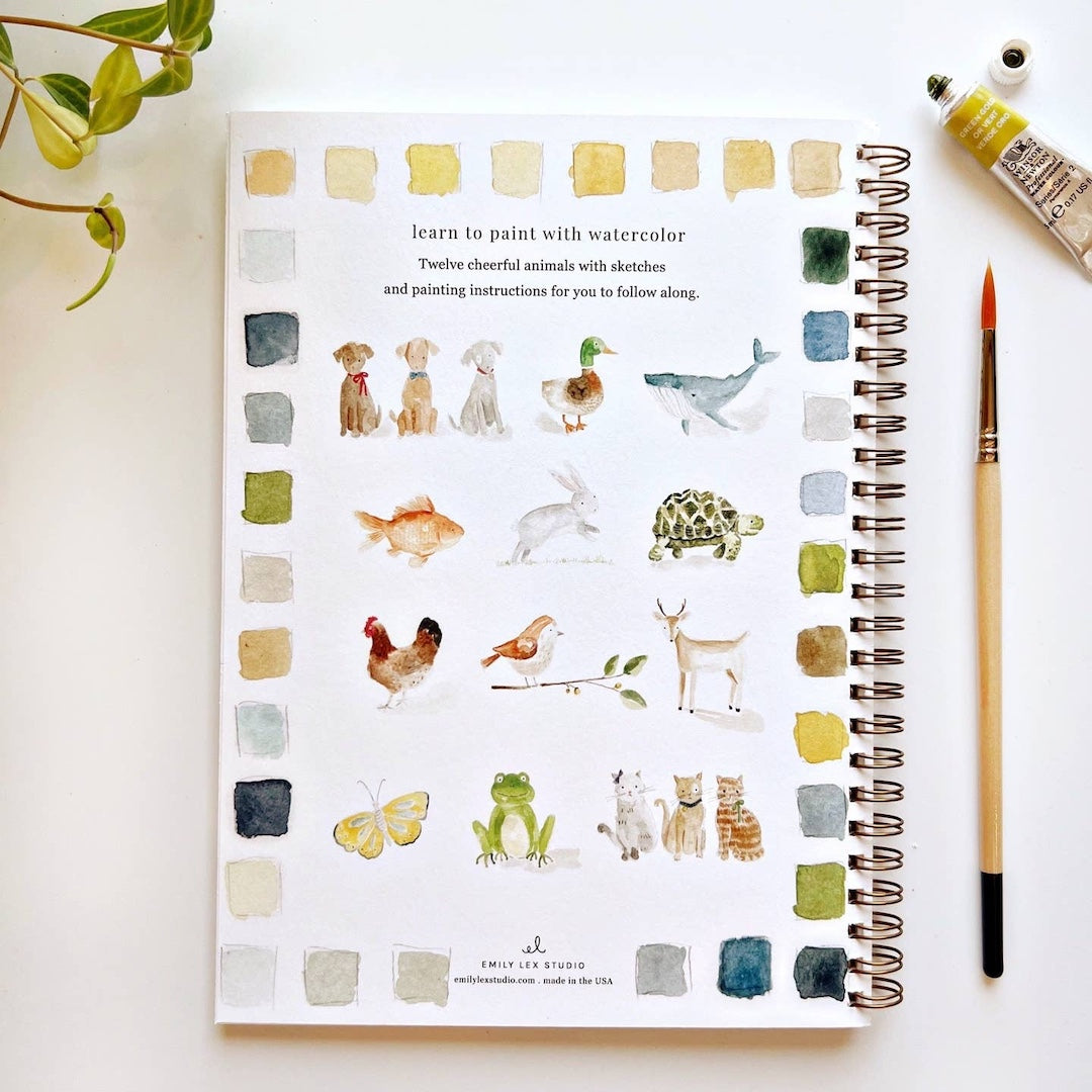 Art book featuring watercolor illustrations of animals on a white surface.