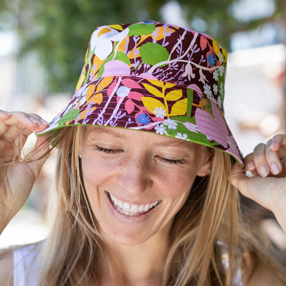 Woman wearing a colorful floral bucket hat outdoors