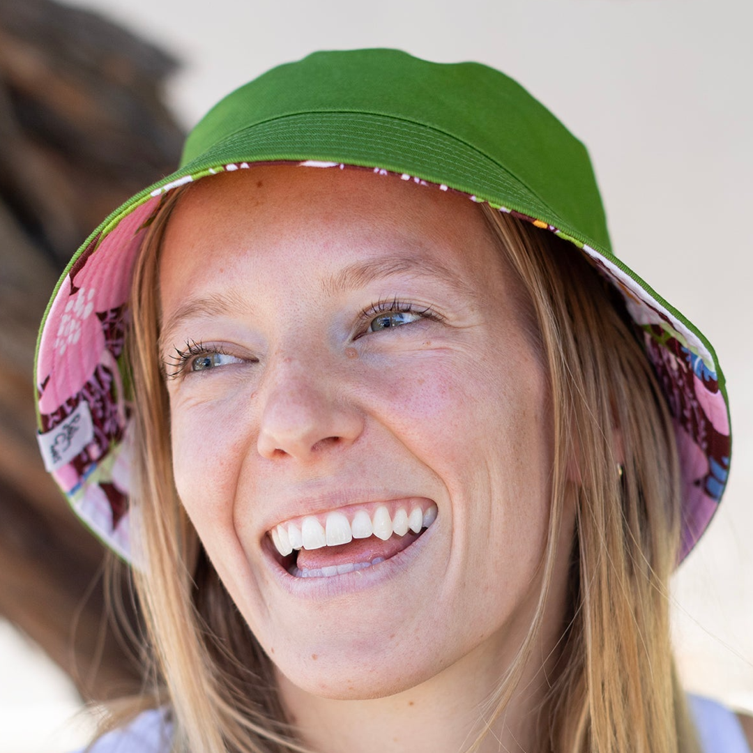 Person wearing a green bucket hat with a blurred background