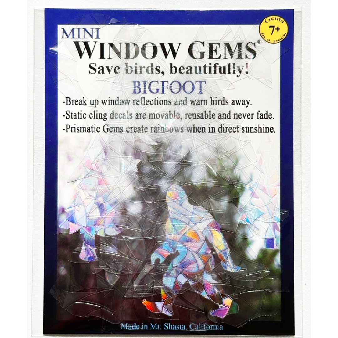 Pack of Mini Window Gems Bigfoot decals, featuring a package insert with text and a preview of the iridescent, rainbow-reflective crystal-like decals applied over a window.