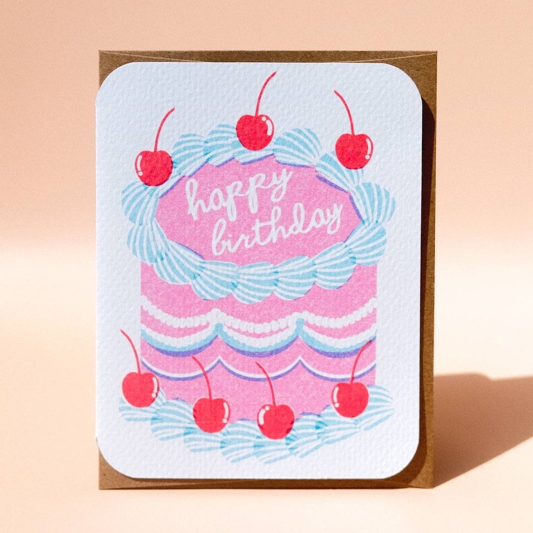 Greeting card with a pink cake that says happy birthday on it