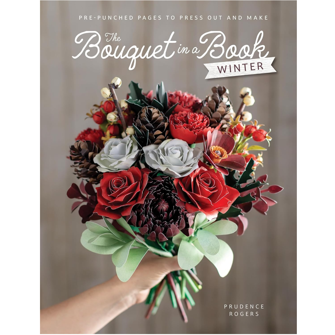 Book cover for 'The Bouquet in a Book: Winter' by Prudence Rogers, featuring a hand holding a colorful paper flower bouquet with red roses, white and gray roses, pinecones, and green leaves against a soft gray background.