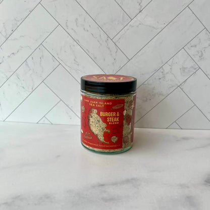 Jar of 'Burger & Steak Blend' seasoning on a marble surface with a white tiled wall background