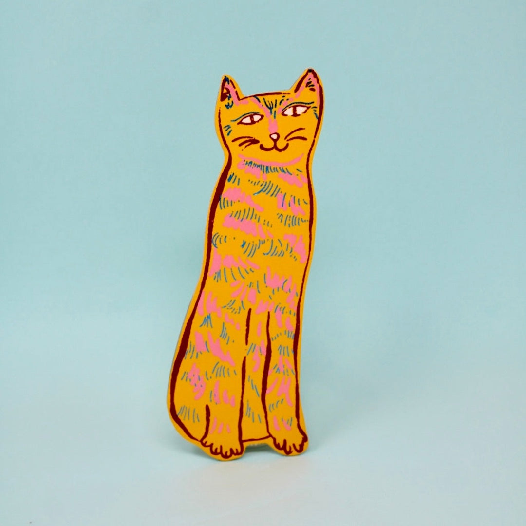 yellow cat shaped leather bookmark on a light blue background