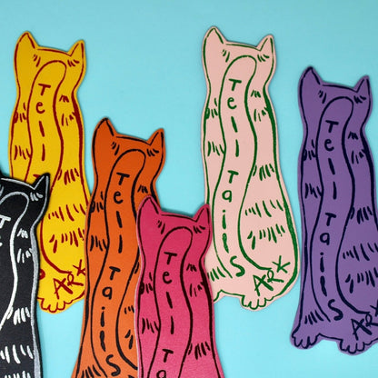 Colorful cat-shaped bookmarks with 'Tell Tails' text on a blue background